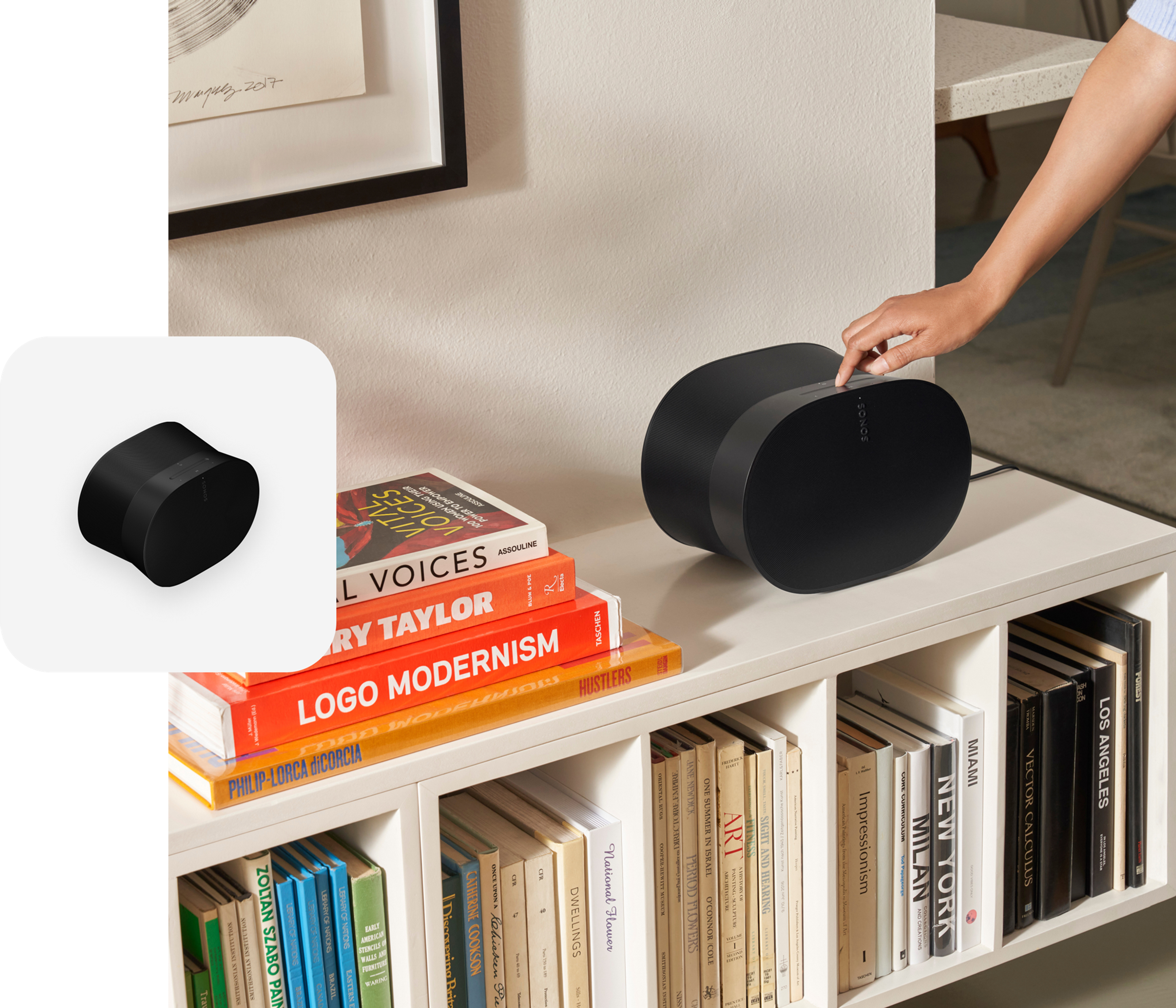 Un usuario utiliza los controles táctiles de una bocina Era 300 en color negro colocada sobre un mueble blanco