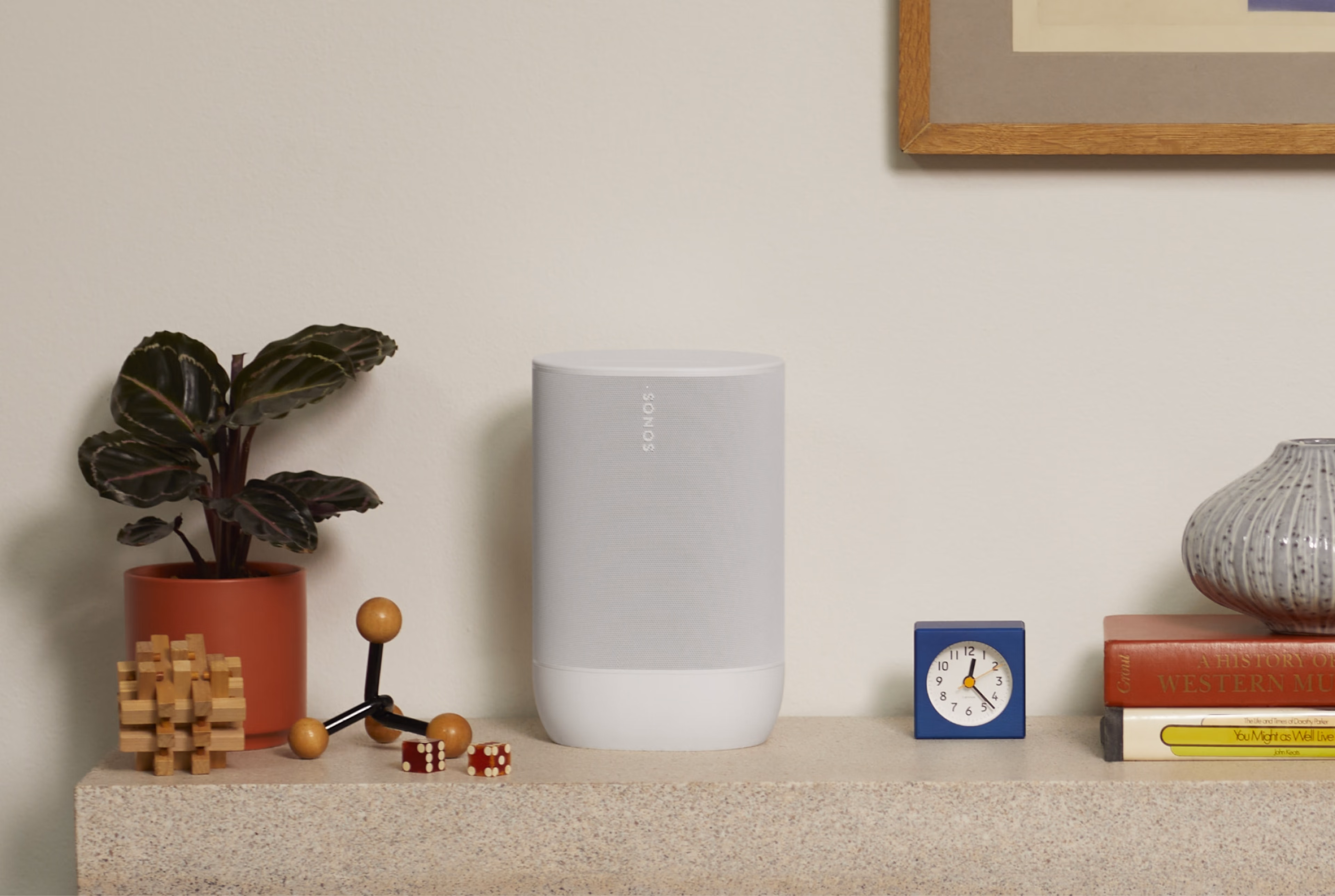 Valkoinen Sonos Move 2 sivupöydällä kasvin vieressä