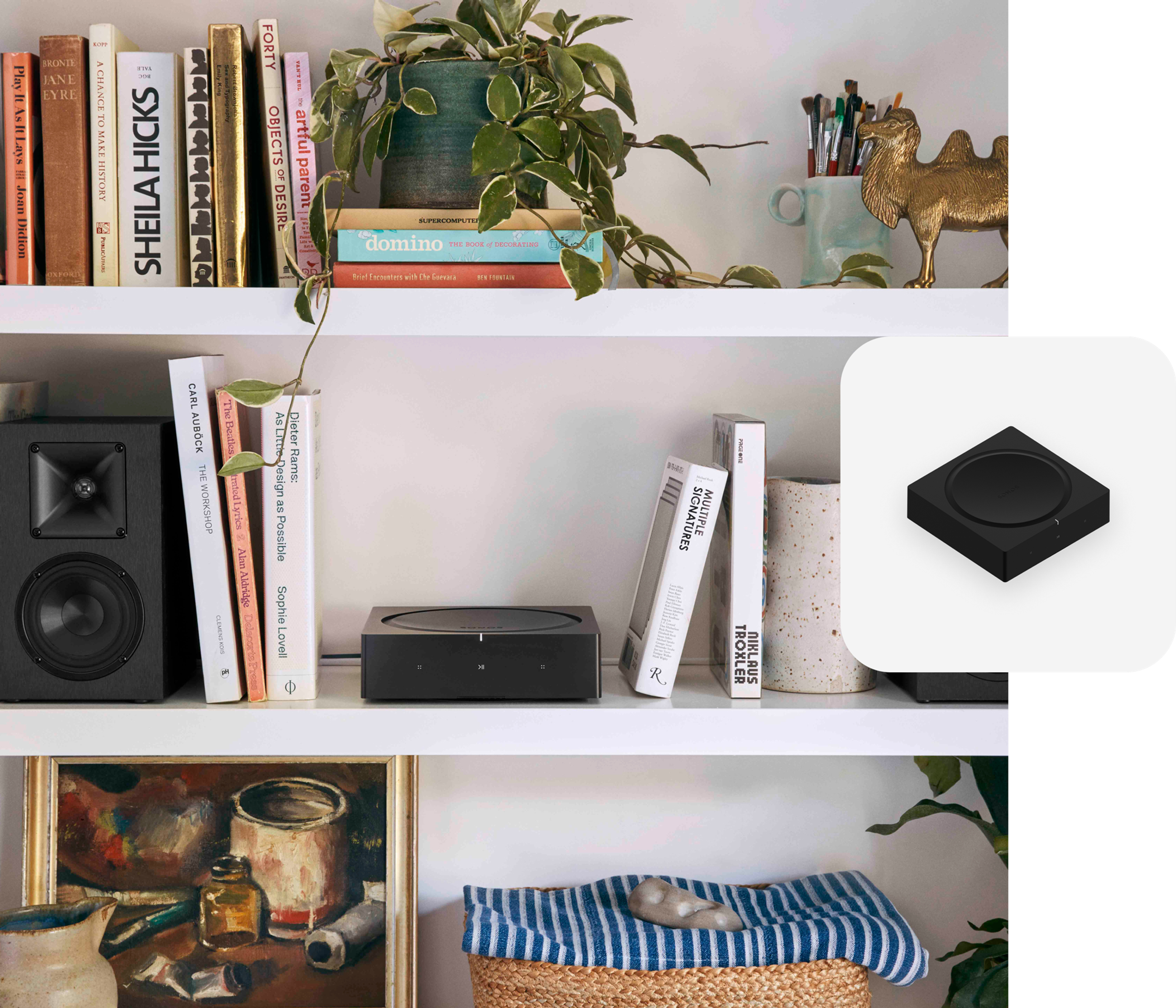 Un Sonos Amp sobre un librero blanco entre un par de bocinas para librero
