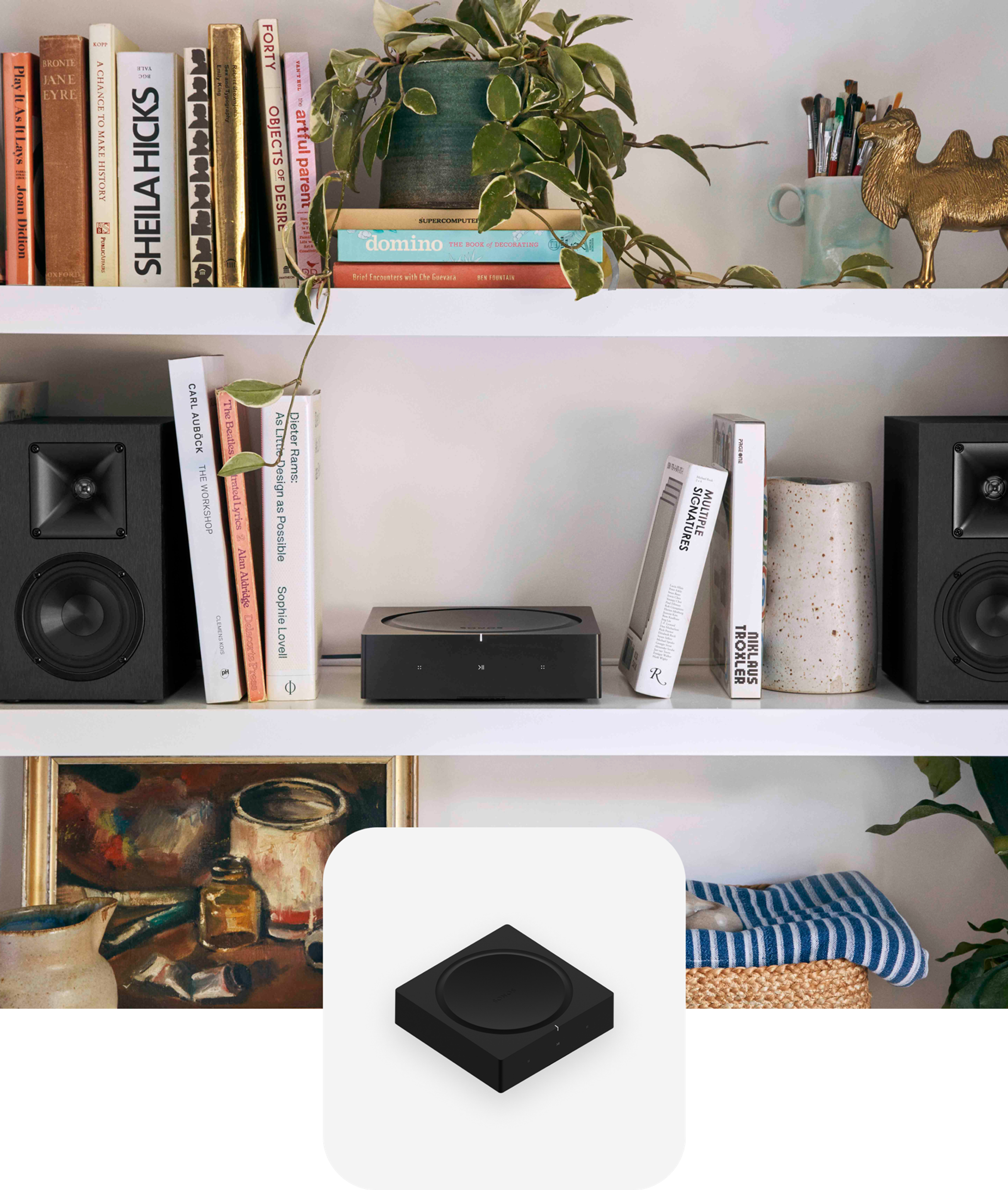 Un Sonos Amp sobre un librero blanco entre un par de bocinas para librero