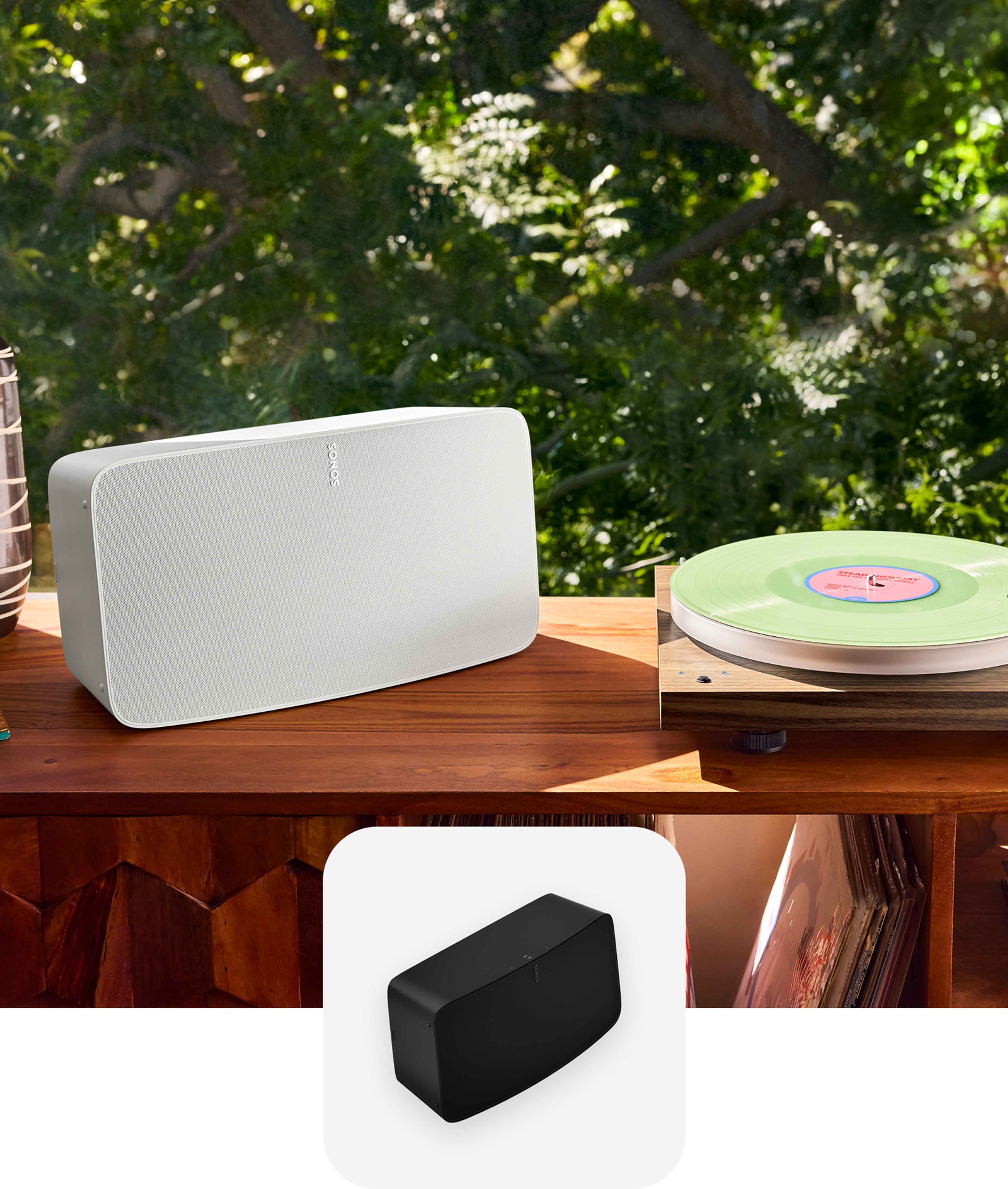 Una bocina Sonos Five en color blanco junto a una tornamesa sobre una consola de discos