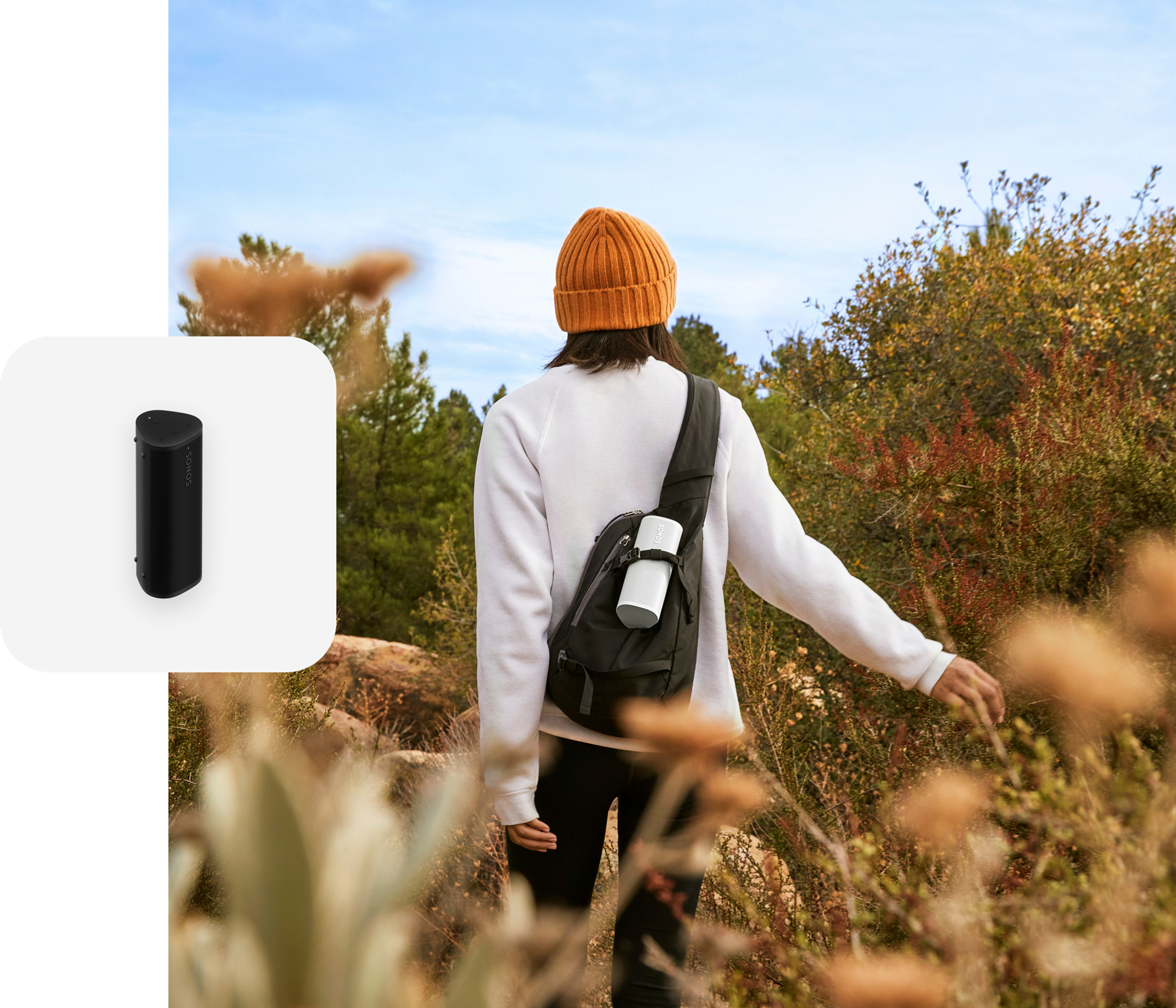 Un usuario practica senderismo mientras escucha una Roam 2 en color blanco que lleva en su mochila
