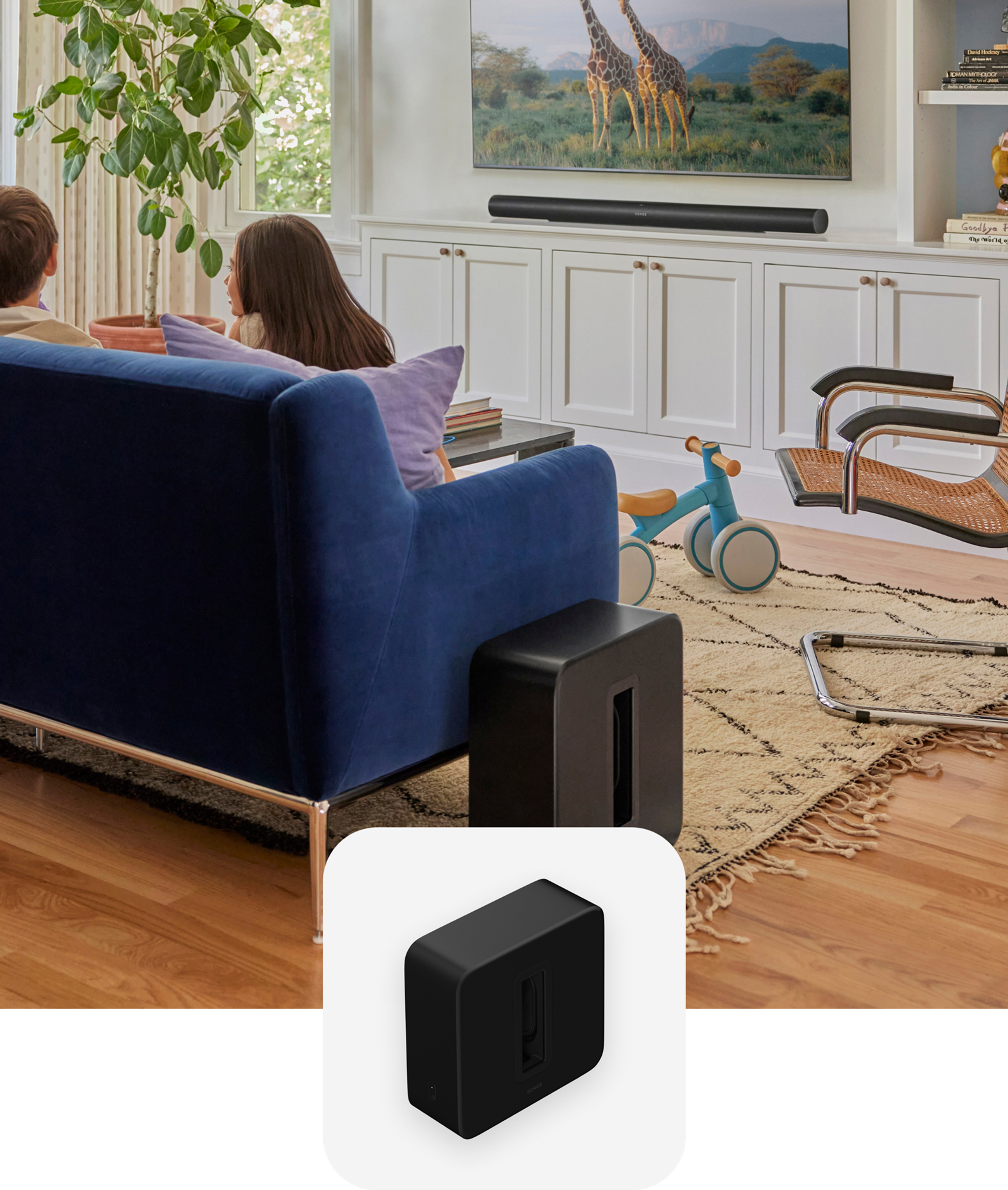 Unos niños sentados en un sofá azul en la sala con Sonos Sub 4 y Arc Ultra en color negro y una fotografía superpuesta de Sub 4 en color negro