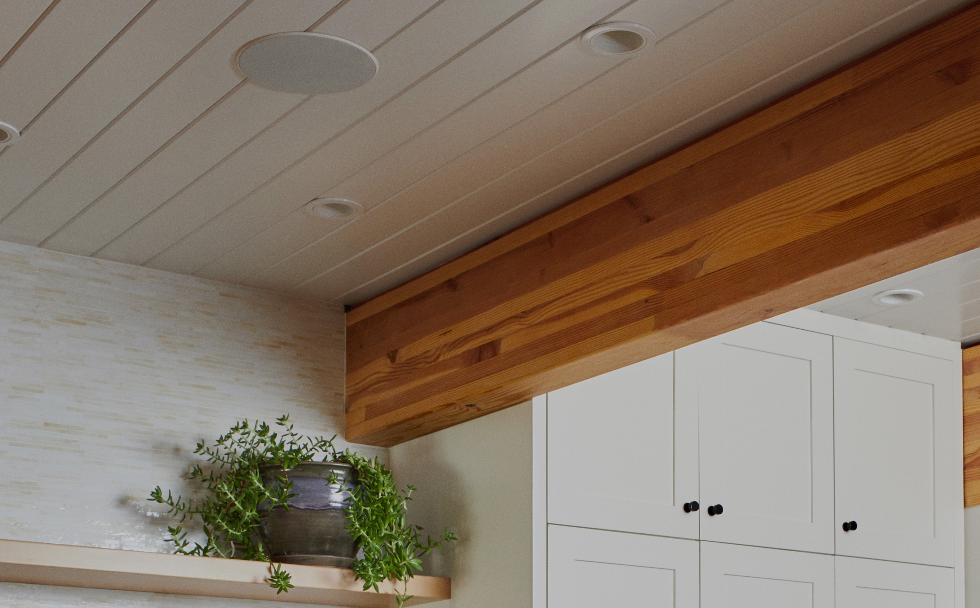 Nærbilde av In-Ceiling-høyttalere av Sonos og Sonance installert i taket over hyller