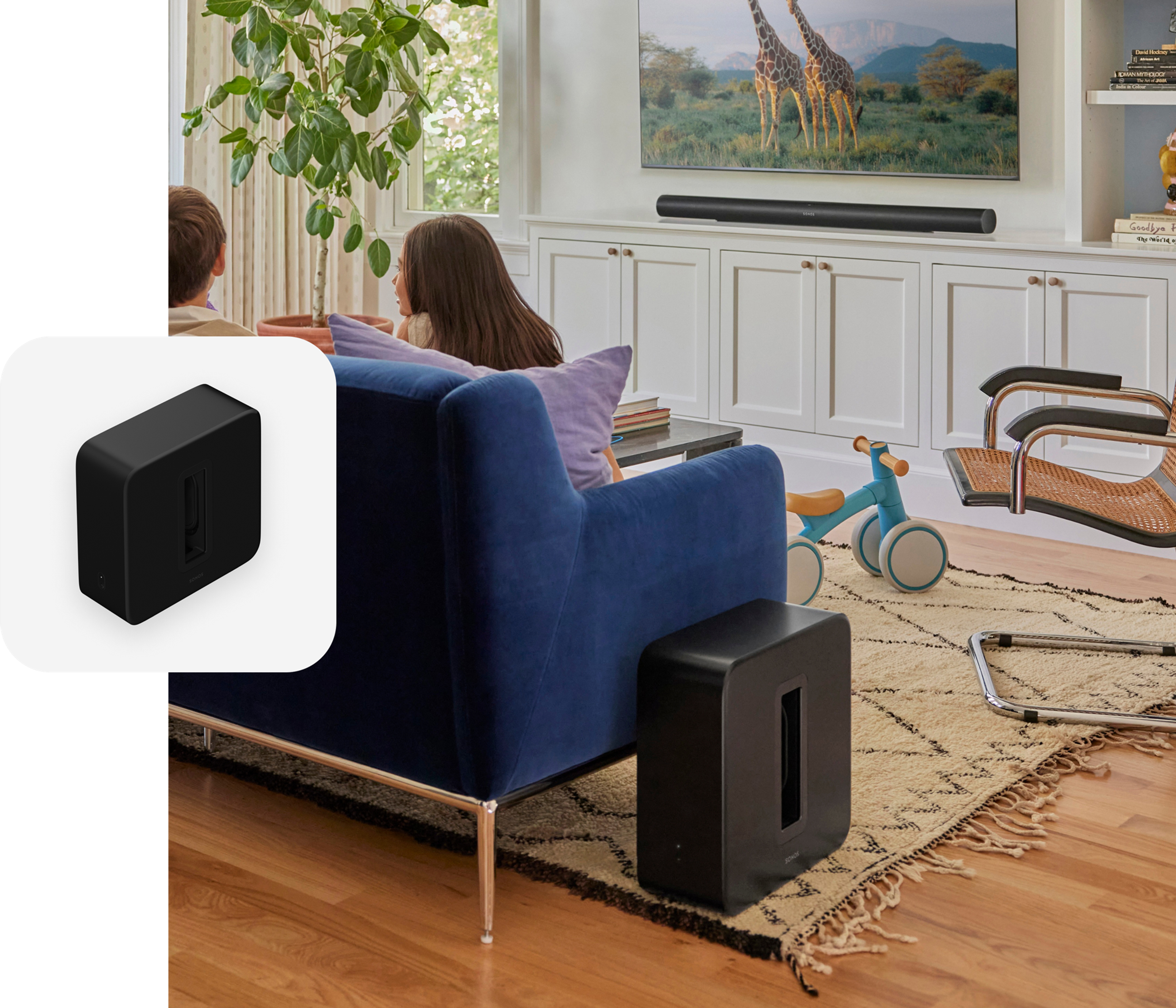 Unos niños sentados en un sofá azul en la sala con Sonos Sub 4 y Arc Ultra en color negro y una fotografía superpuesta de Sub 4 en color negro