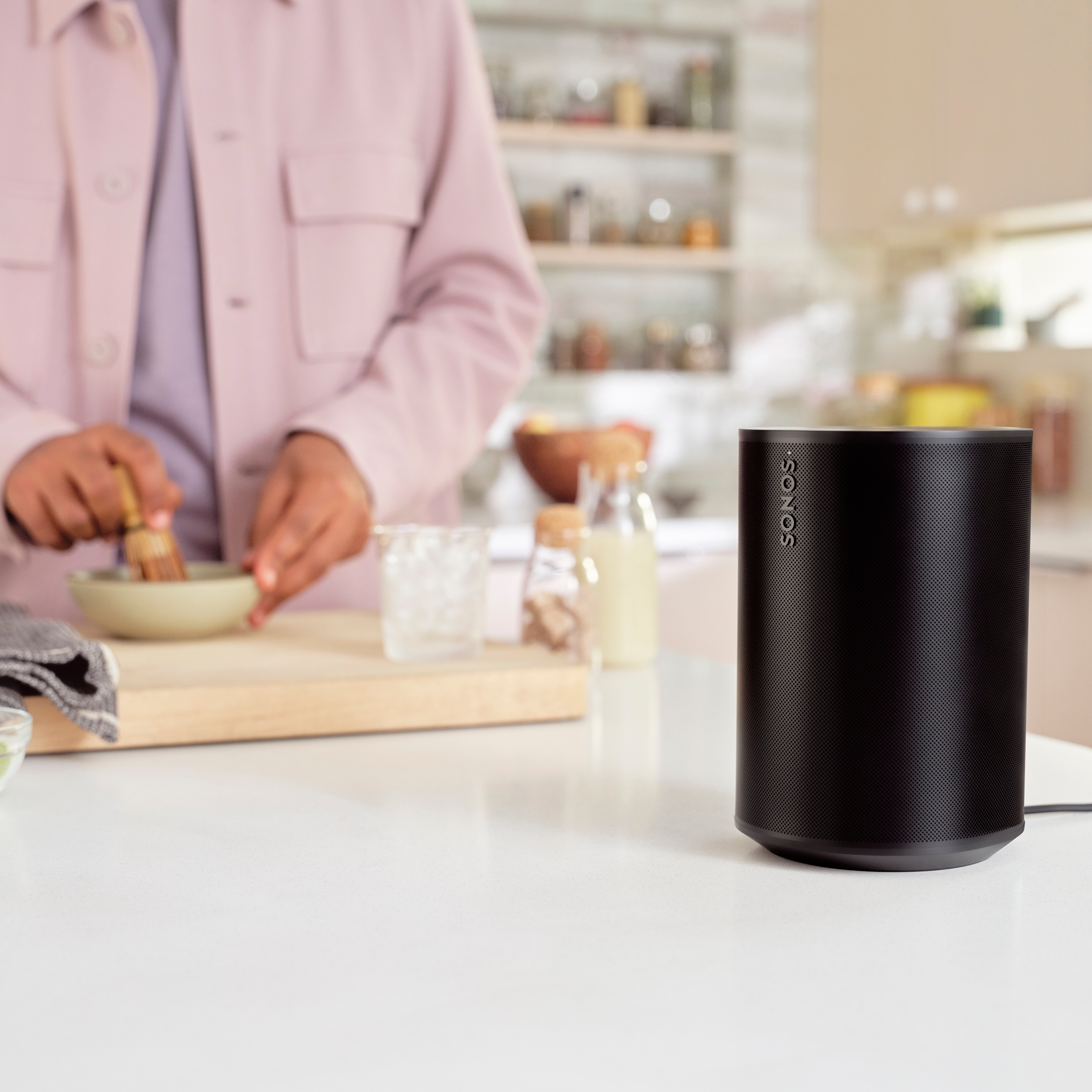 Enceinte Sonos Era 100 noire, sur un plan de travail de cuisine